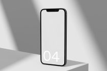 iPhone mockup standing upright with white 04 on minimal gray surface