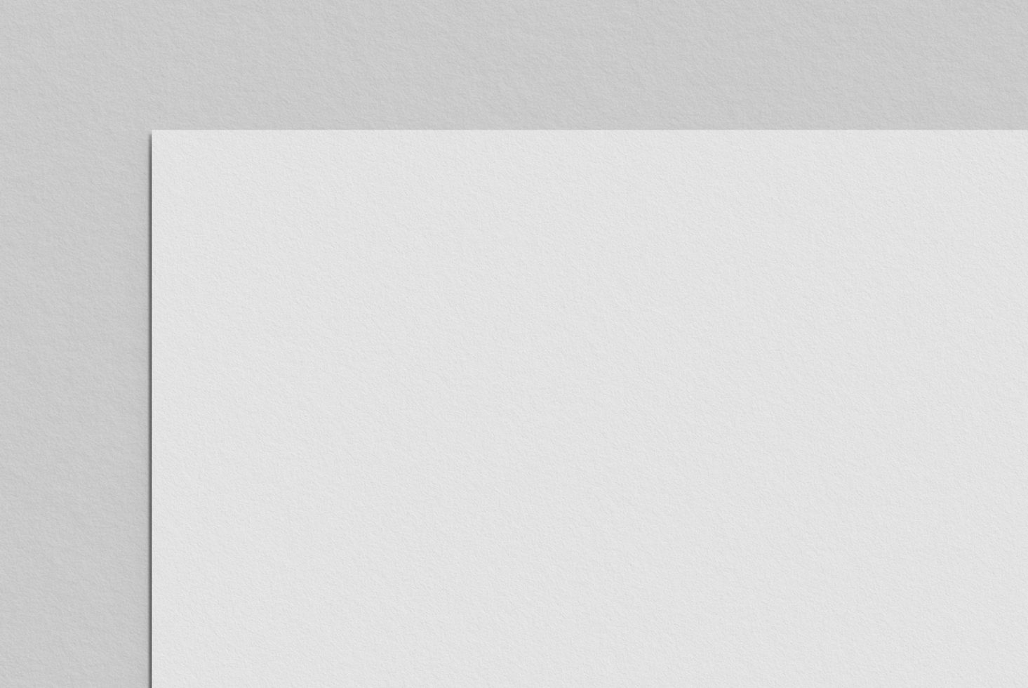 Blank white paper mockup on a textured grey background, ideal for presentations and branding designs.