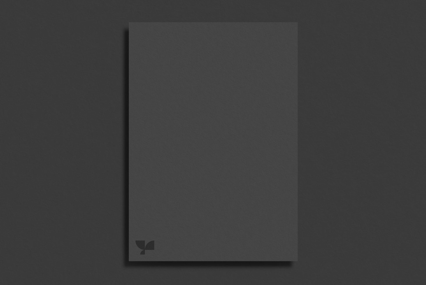 Elegant black paper brochure mockup on a dark surface, ideal for showcasing graphic design and typography work for designers.