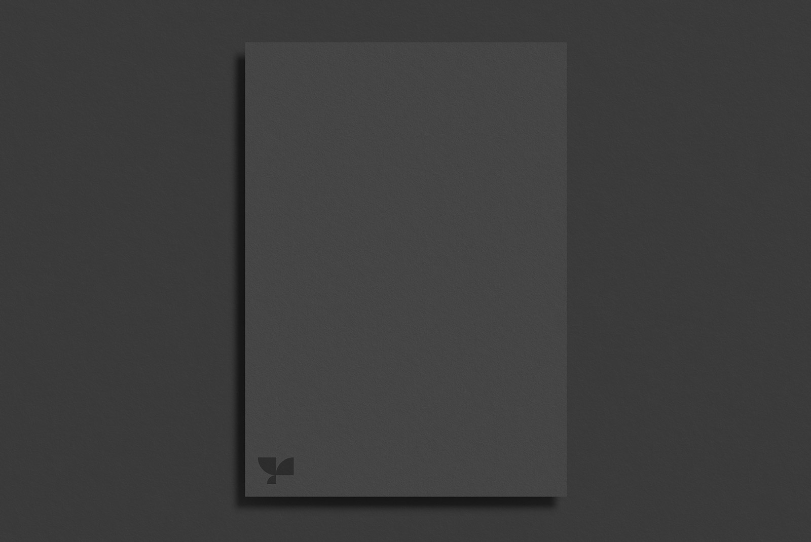 Elegant black paper brochure mockup on a dark surface, ideal for showcasing graphic design and typography work for designers.