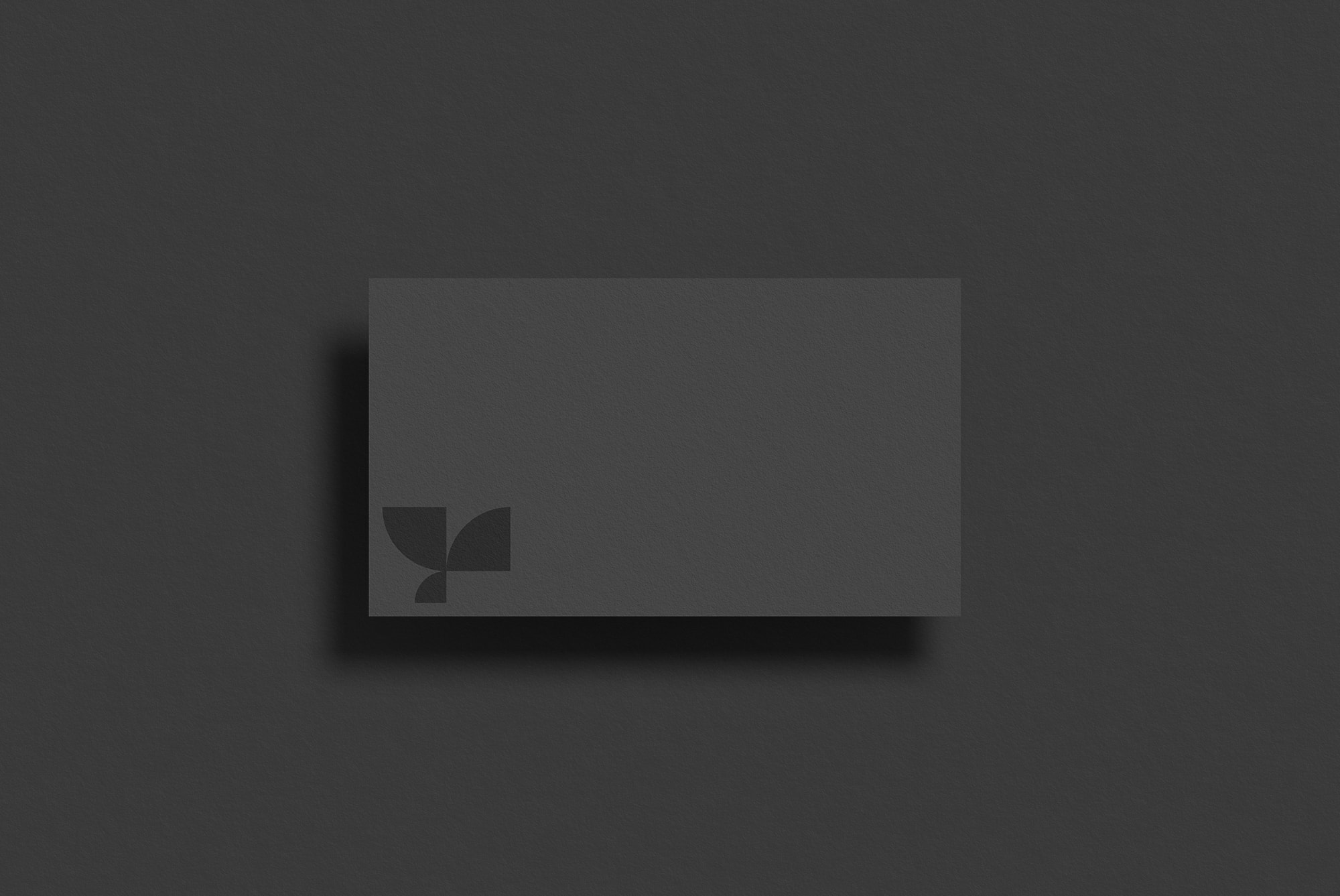 Elegant black business card mockup on dark background, minimalistic design, ideal for professional branding presentation.