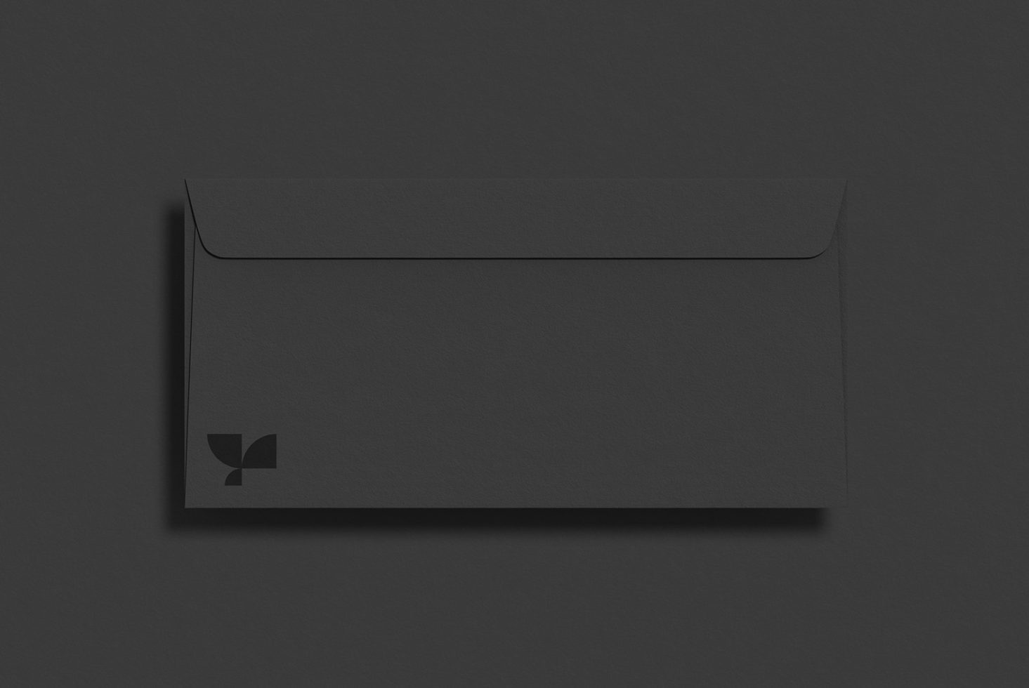 Black envelope mockup with minimalist branding on dark background, perfect for presentation and graphic design assets.