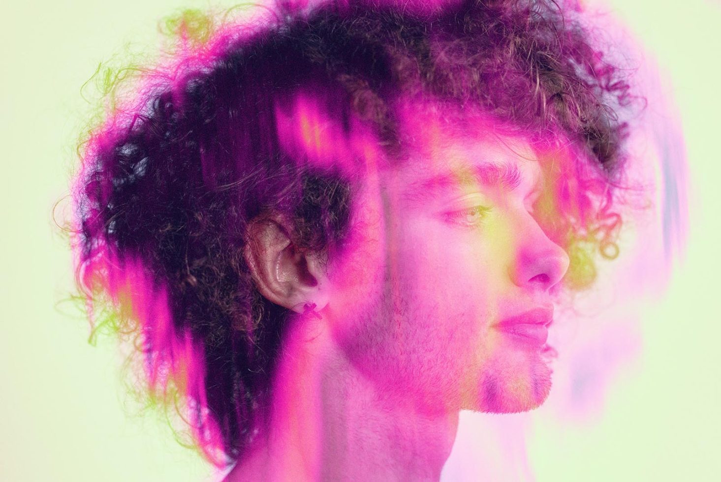 Profile of a male with curly hair in a colorful light overlay, ideal for vibrant graphics or photomanipulation templates.