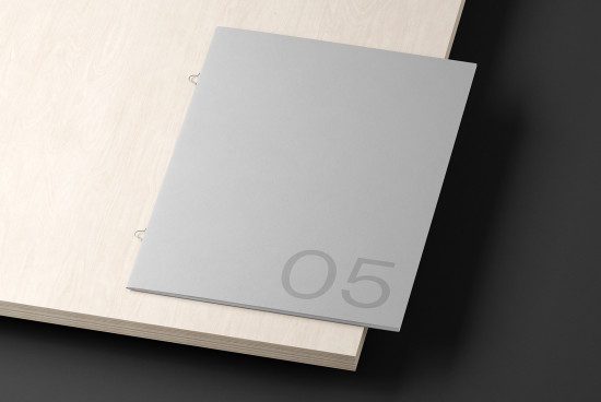 Minimalist magazine mockup on a wooden surface with shadow overlay, ideal for sleek design presentations and portfolio displays.