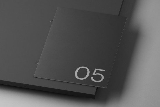 Minimalist black portfolio mockup with subtle shadows and number detail for showcasing graphic design work.