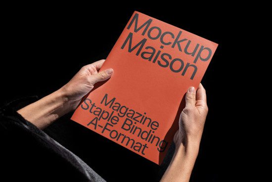 Hands holding a red magazine mockup with text, ideal for designers looking to display their work in a professional realistic template.