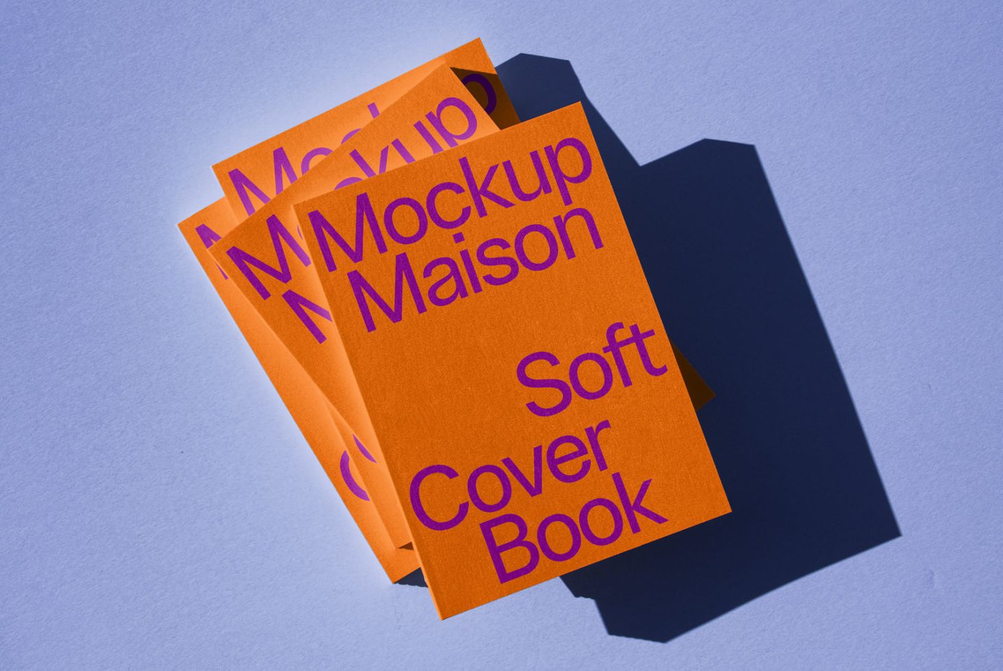 Orange softcover book mockup stack with purple text on a blue background, ideal for graphic designers to display cover designs.