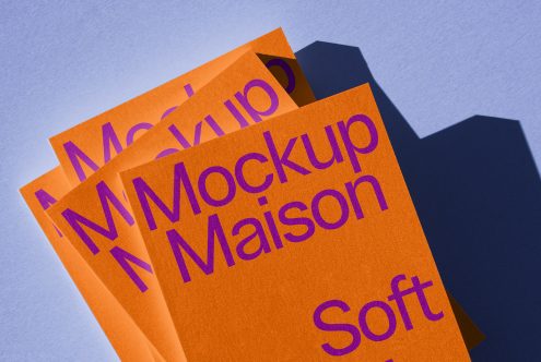 Colorful mockup brochures with dynamic shadows on a blue background, showcasing print design and font use for creative assets.