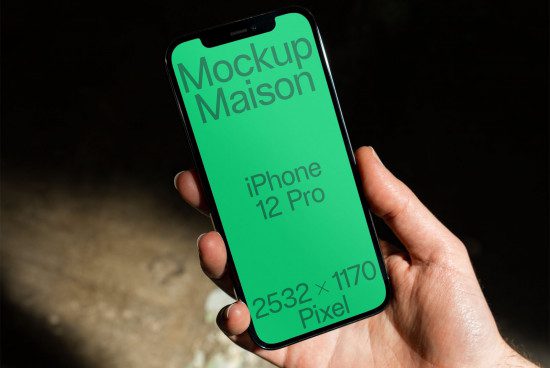 Hand holding iPhone 12 Pro mockup with green screen for design presentation, high resolution, clear smartphone display, digital asset.