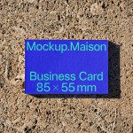 Blue business card mockup on a textured sand background, showcasing professional design dimensions 85 x 55 mm, ideal asset for designers.