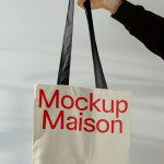 Canvas tote bag mockup held by a hand with red "Mockup Maison" text, ideal for showcasing design prototypes and patterns.