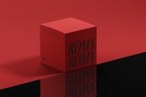 Bright red cube box with Roma Roma text on dark reflective surface