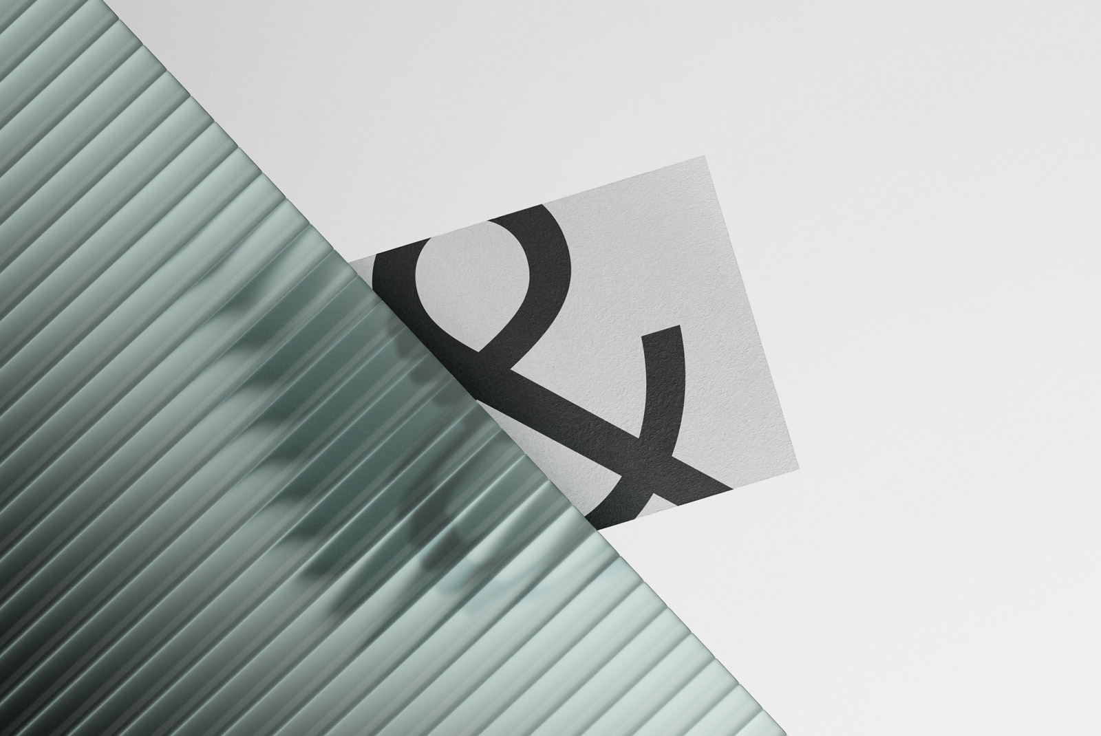 Elegant font letter mockup on paper against a ribbed glass background, showcasing typography design and print presentation.