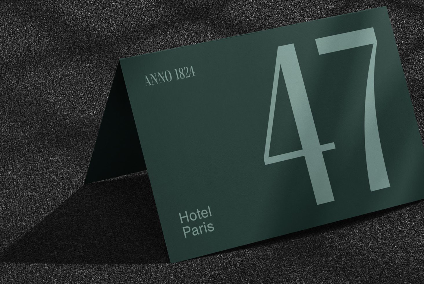 Elegant dark green hotel key card mockup on textured background, showcasing modern typography and minimalistic design for branding.