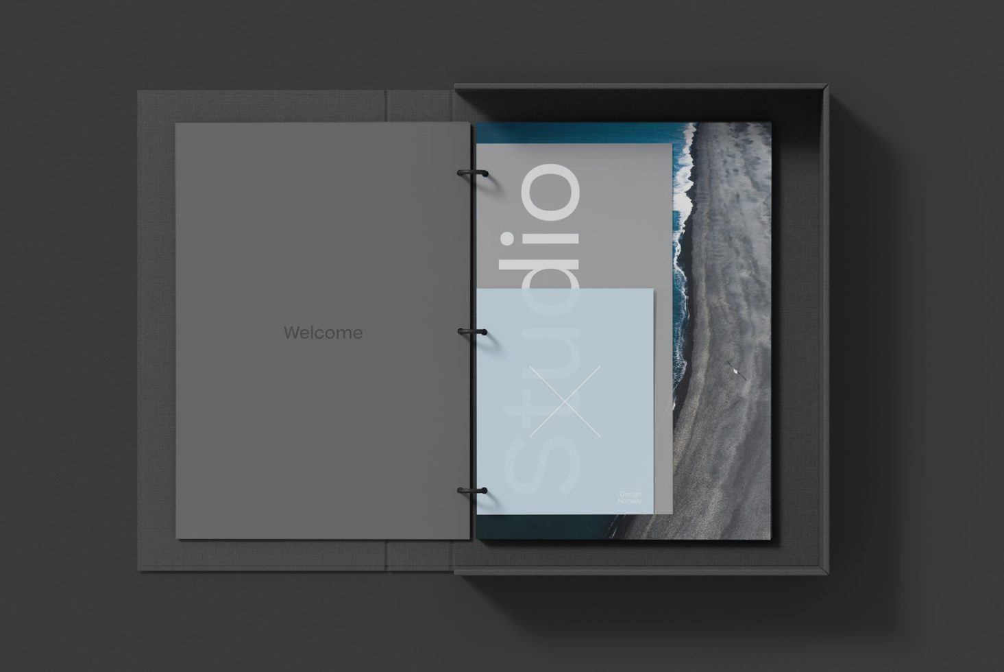 Elegant portfolio mockup featuring open book with studio branding beside coastal photo print inside a sleek box, ideal for designers' presentations.