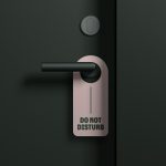 Elegant door handle with 'Do Not Disturb' sign mockup for hotel branding, realistic 3D design, isolated on dark background, editable template graphic.