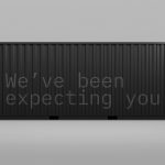 Realistic cargo container mockup with the text We've been expecting you on a grey background suitable for designers' product presentation.