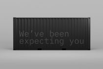 Realistic cargo container mockup with the text We've been expecting you on a grey background suitable for designers' product presentation.