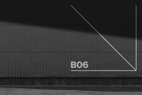 Minimalist black wall facade with abstract white geometric shape and typography B06, perfect for modern design mockups and graphic backgrounds.