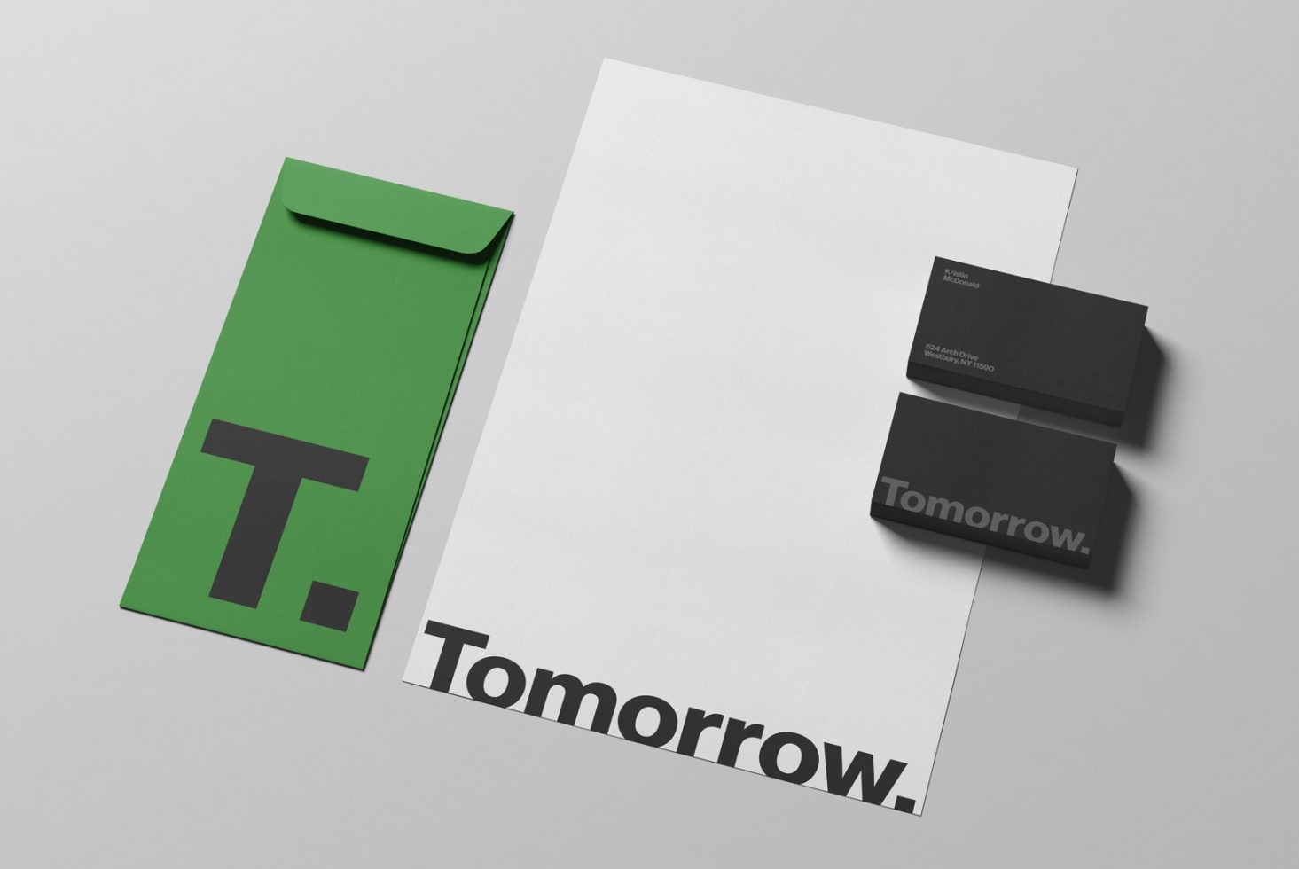 Stationery mockup with envelope, letterhead, and business cards on a gray background showcasing branding with the word Tomorrow.