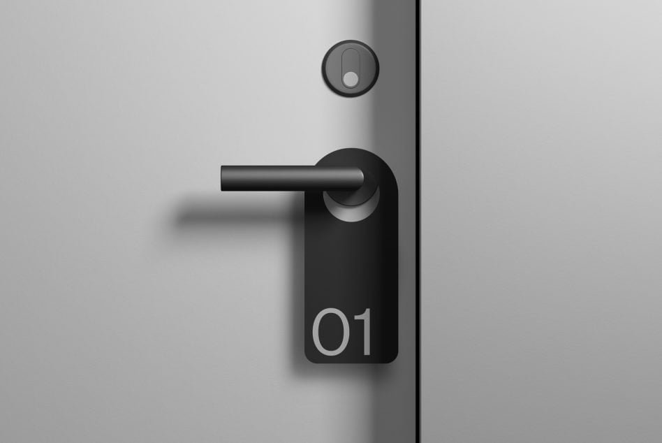 Black door handle with numbered tag 01 on white wall
