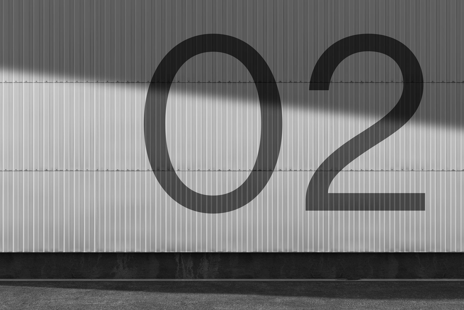 Industrial style font mockup on metal wall, showcasing bold number 02 design, perfect for poster, logo, and graphic design projects.