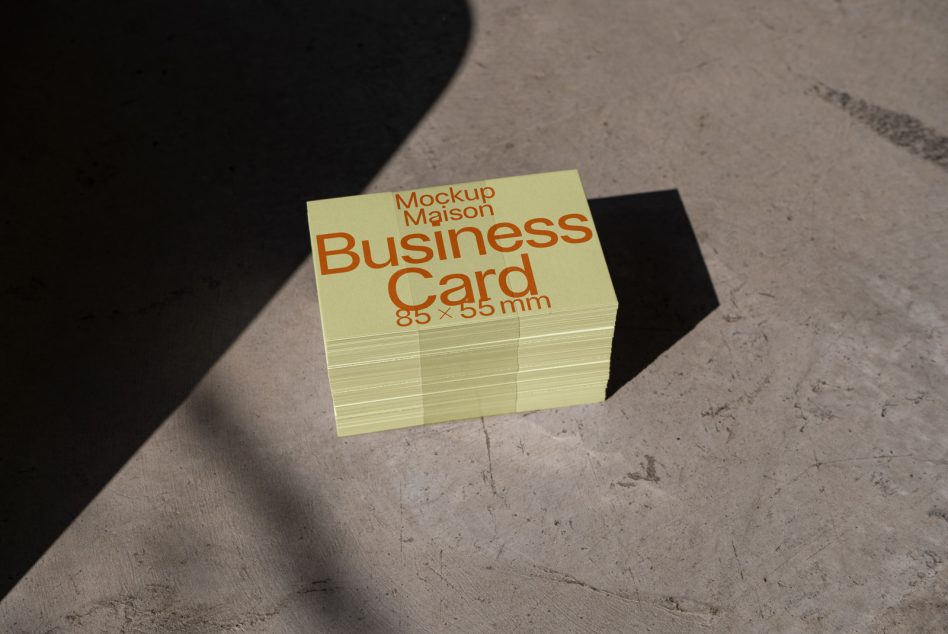 Stack of business card mockups with shadow overlay on concrete surface, ideal for graphic design and branding presentations.