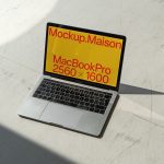 Laptop mockup on a white surface with sunlight casting shadows, displaying screen resolution, ideal for MacBook Pro template designs.