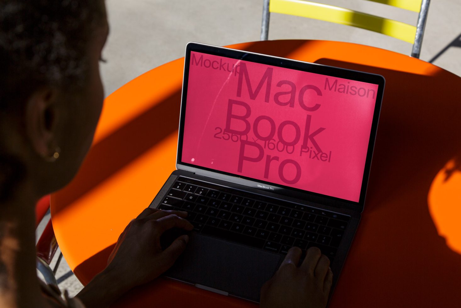 Person using laptop mockup with pink screen for design display, realistic environment, digital asset for graphic designers.