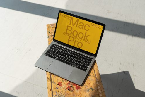 Laptop mockup on wooden desk with shadow overlay, featuring editable screen for design presentations, ideal for graphics and templates.