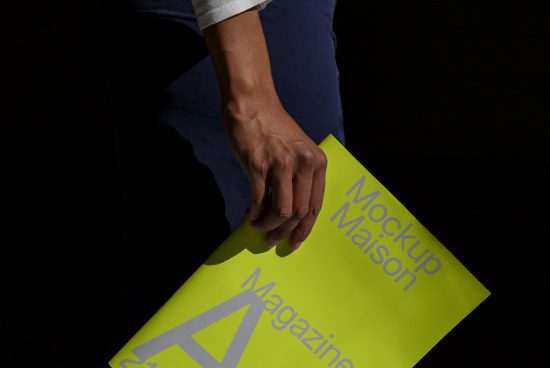 Person holding neon green magazine mockup with visible text, ideal for graphic design and branding presentations.