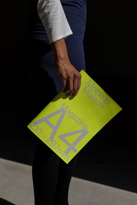 Professional holding A4 magazine mockup with bright neon color, ideal for presentations and portfolio display.