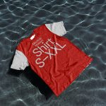 Red t-shirt mockup floating on clear water surface, ideal for presenting apparel designs and patterns in a unique context.