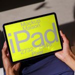 Person holding a tablet displaying digital iPad mockup template in bright yellow, resolution 2732x2048 pixels, ideal for designers' presentations.