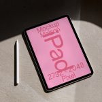 Tablet mockup with stylus pen on concrete surface showcasing bold pink digital design in natural light, ideal for presentations and digital assets.