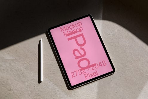 Tablet mockup with stylus pen on concrete surface showcasing bold pink digital design in natural light, ideal for presentations and digital assets.