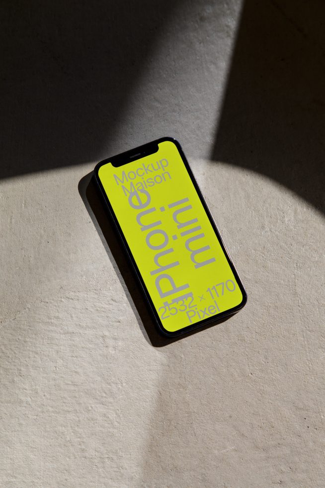 Smartphone mockup with neon yellow screen showcasing font, sunlit concrete background. Ideal for graphic design, UI presentation, template display.