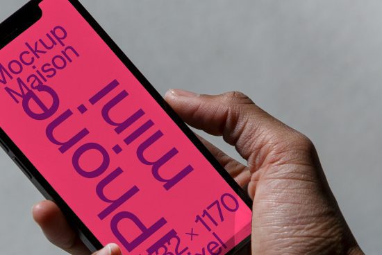 ALT: Close-up of a hand holding a smartphone displaying a pink mockup design, ideal for designers creating mobile presentations.