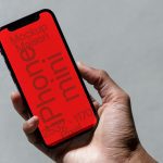 Hand holding smartphone with red screen mockup for design presentation, clear typography, high resolution display, modern mobile mockup.