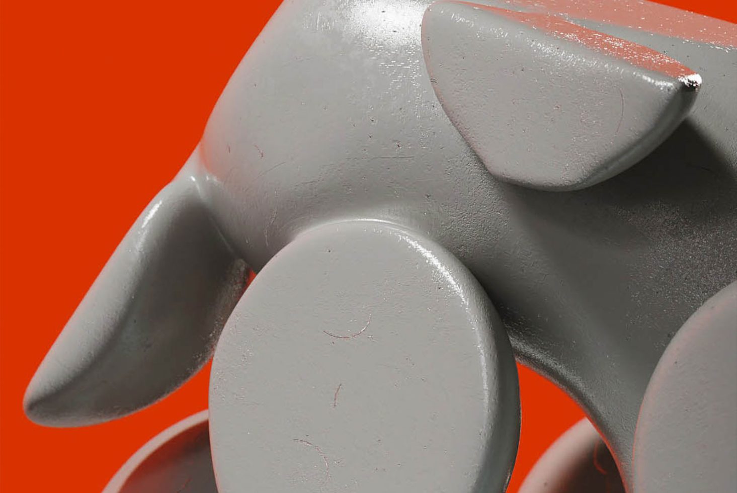 Close-up of a gray balloon dog sculpture on an orange background, ideal for modern design graphics and quirky mockups.