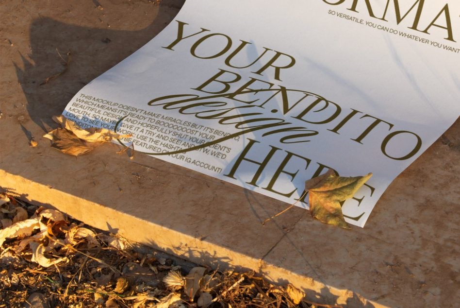 White A4 bendito mockup folded on damp ground with golden autumn leaves scattered