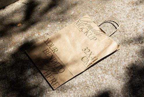 Paper bag mockup on textured ground with natural shadows, ideal for eco-friendly branding presentations and packaging designs.