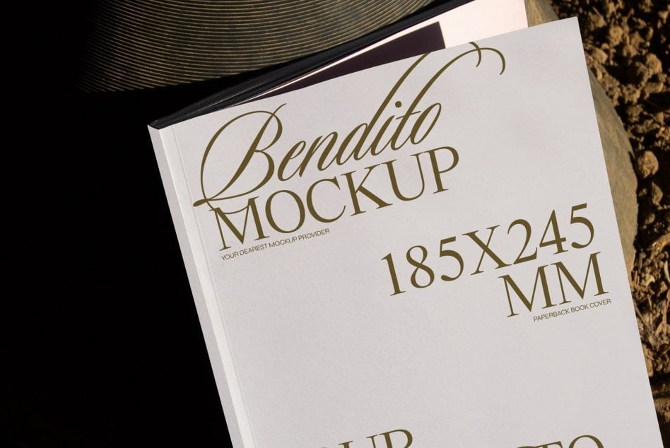 Paperback book mockup 185x245mm shot from above on wooden surface with stacked papers