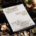 Paperback book mockup lying on a bed of autumn leaves, showcasing customizable cover design for designers, suitable for graphic presentations.