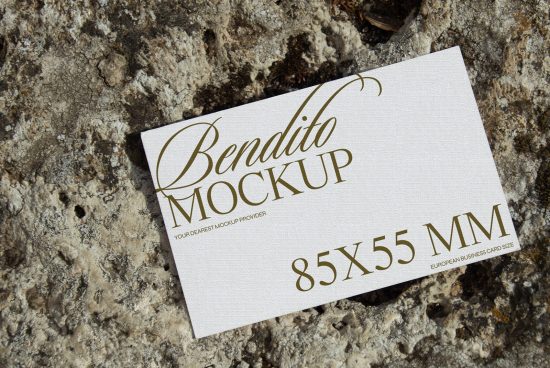 Elegant business card mockup on textured stone background, showcasing calligraphy font, suitable for graphic design assets.