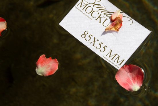 Elegant business card mockup floating on water surrounded by pink flower petals, reflecting a serene, professional design aesthetic for branding.