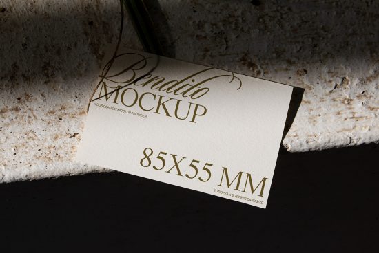 Elegant business card mockup with gold foil script on textured background, showcasing design and typography for creative professionals.