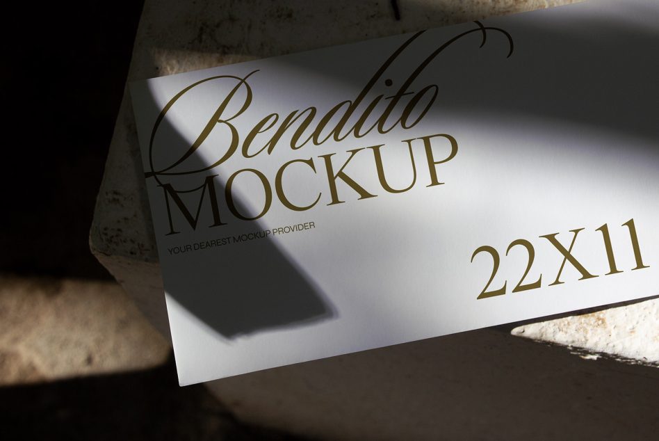 Horizontal paper mockup on concrete with dramatic diagonal sunlight casting shadows