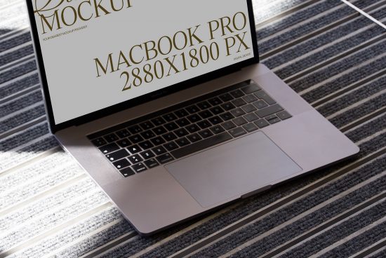 Laptop on striped carpet displaying screen mockup, MacBook Pro design preview, digital asset for graphic designers, template showcase.