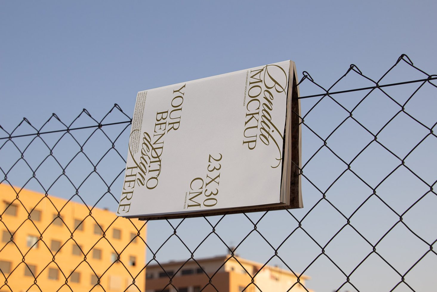 Outdoor poster mockup hanging on a chain-link fence with city background, perfect for designers to showcase advertising designs.